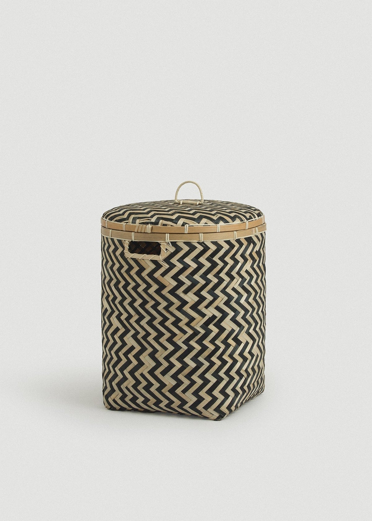 Medium cylindrical bamboo basket displaying the bold black chevron pattern.