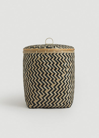 Large bamboo storage basket with a fitted lid, loop handle, and bold black-and-natural zigzag weave.
