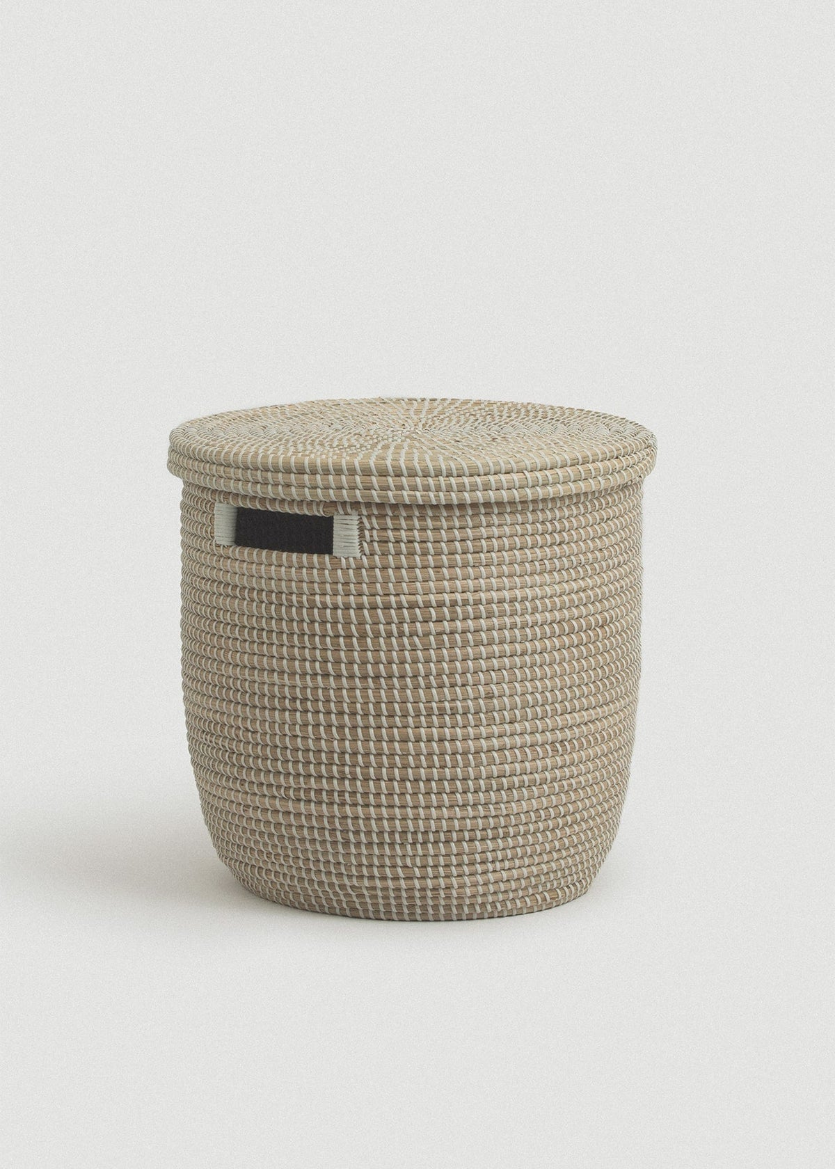 Natural woven seagrass storage basket with a flat fitted lid and rectangular black side handle.