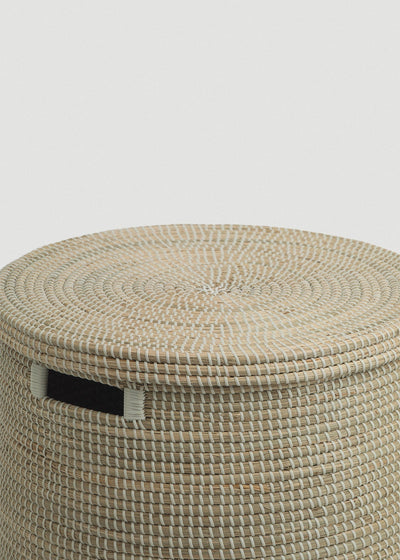 Close-up of the spiral-woven flat lid, basket rim, and black rectangular handle.