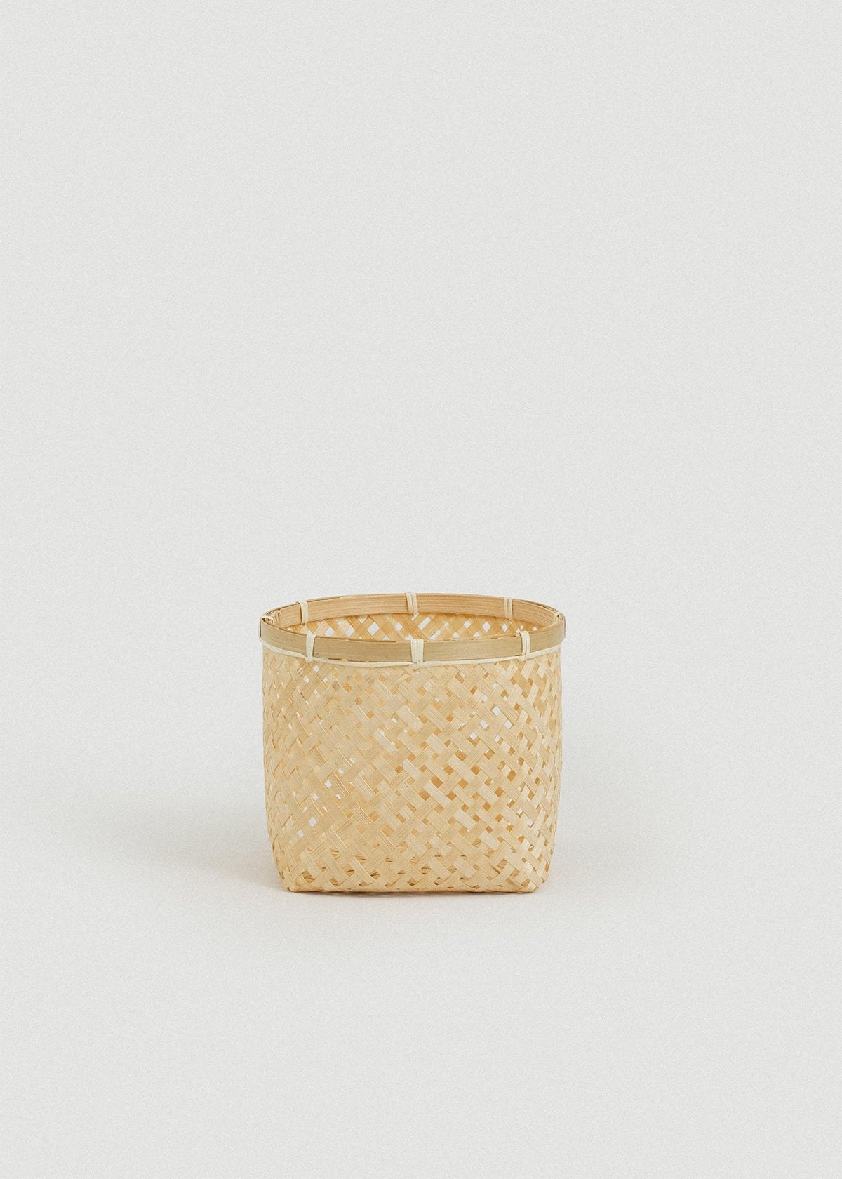 Small square bamboo basket shown alone against a light neutral background.