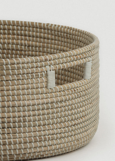 Close-up of the natural seagrass weave, thick rounded edge, and rectangular handle.