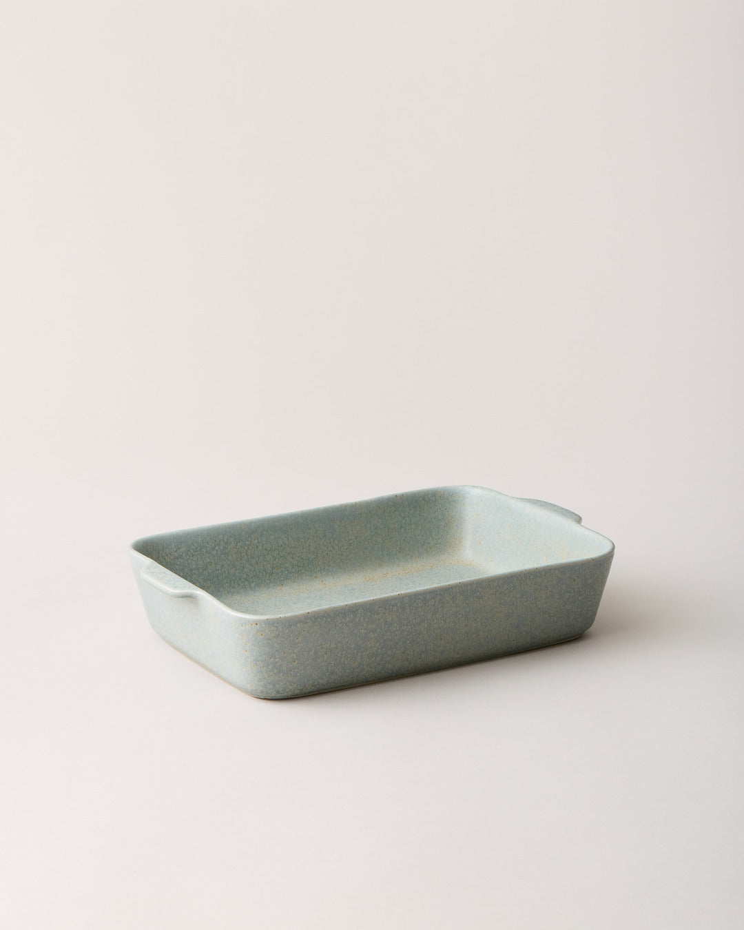 Empty blue-gray Fieldstone Baker with a pale celadon-toned glaze, rounded corners, and small integrated handles.