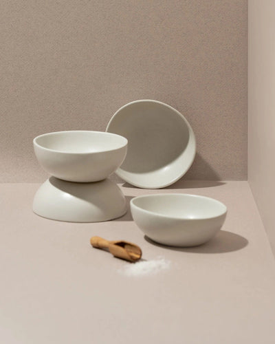 Stoneware bowls in Matte White stacked with wood spoon on neutral background