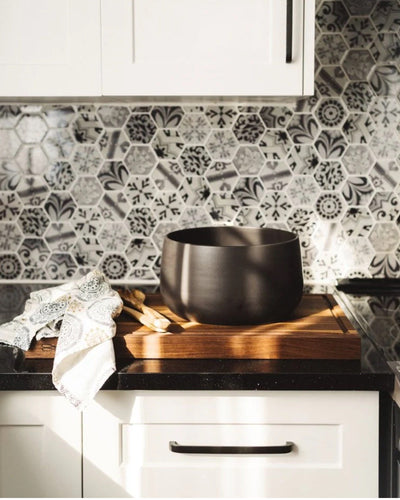 Stoneware serving bowl 120 oz in Matte Black styled on kitchen counter with cutting board