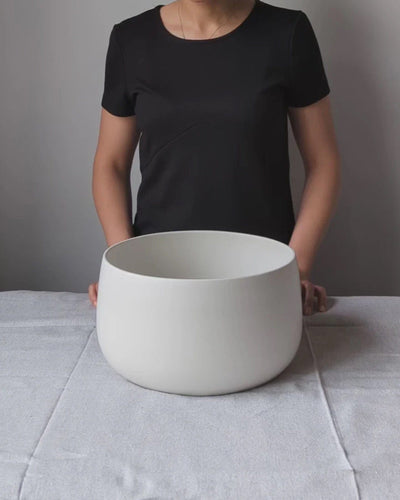 Person holding stoneware serving bowl 120 oz in Matte White to show scale
