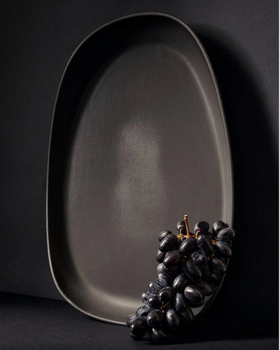 Stoneware long serving platter in Matte Black with fresh grapes on dark background
