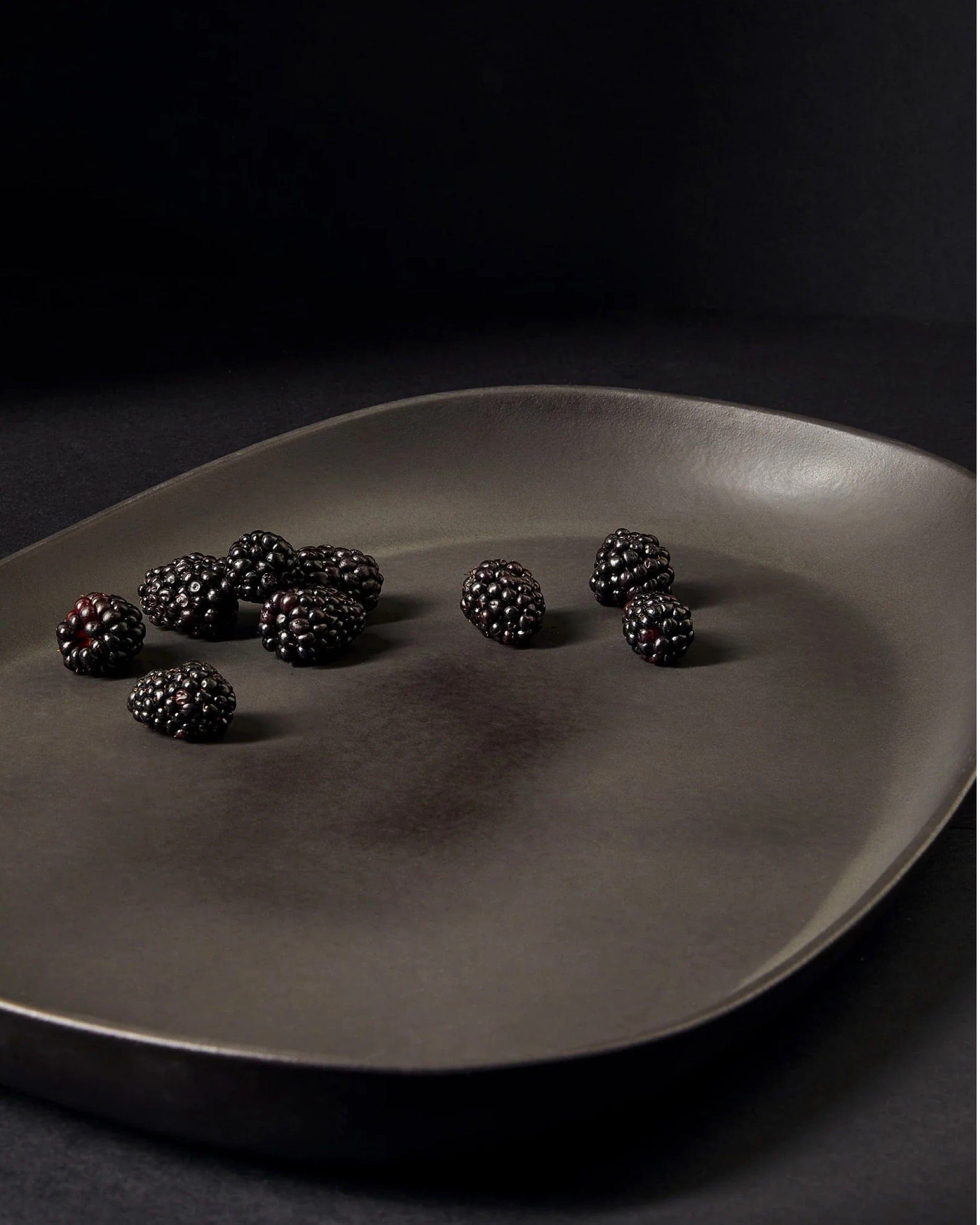 Stoneware long serving platter in Matte Black with fresh blackberries