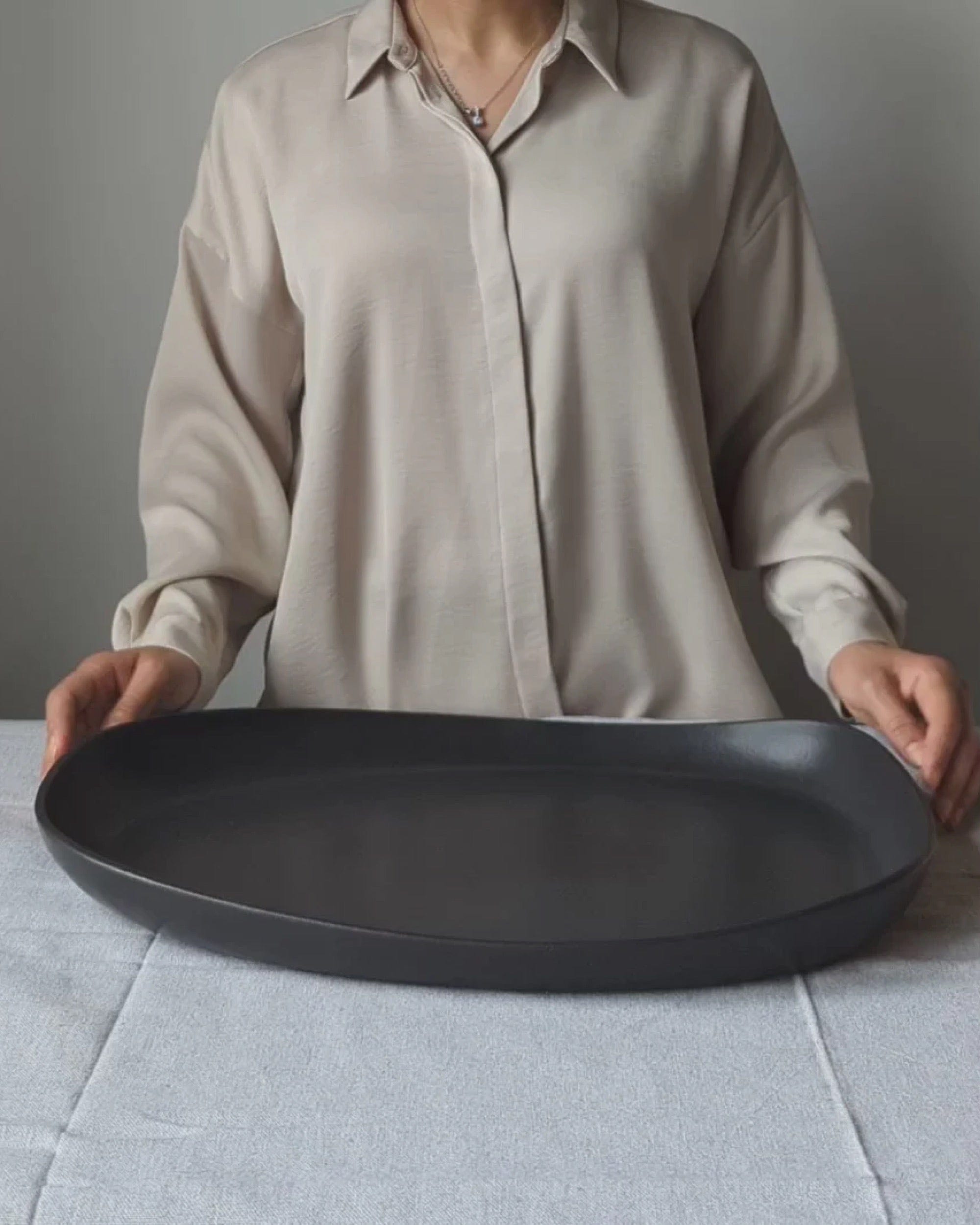 Person holding stoneware long serving platter in Matte Black to show scale