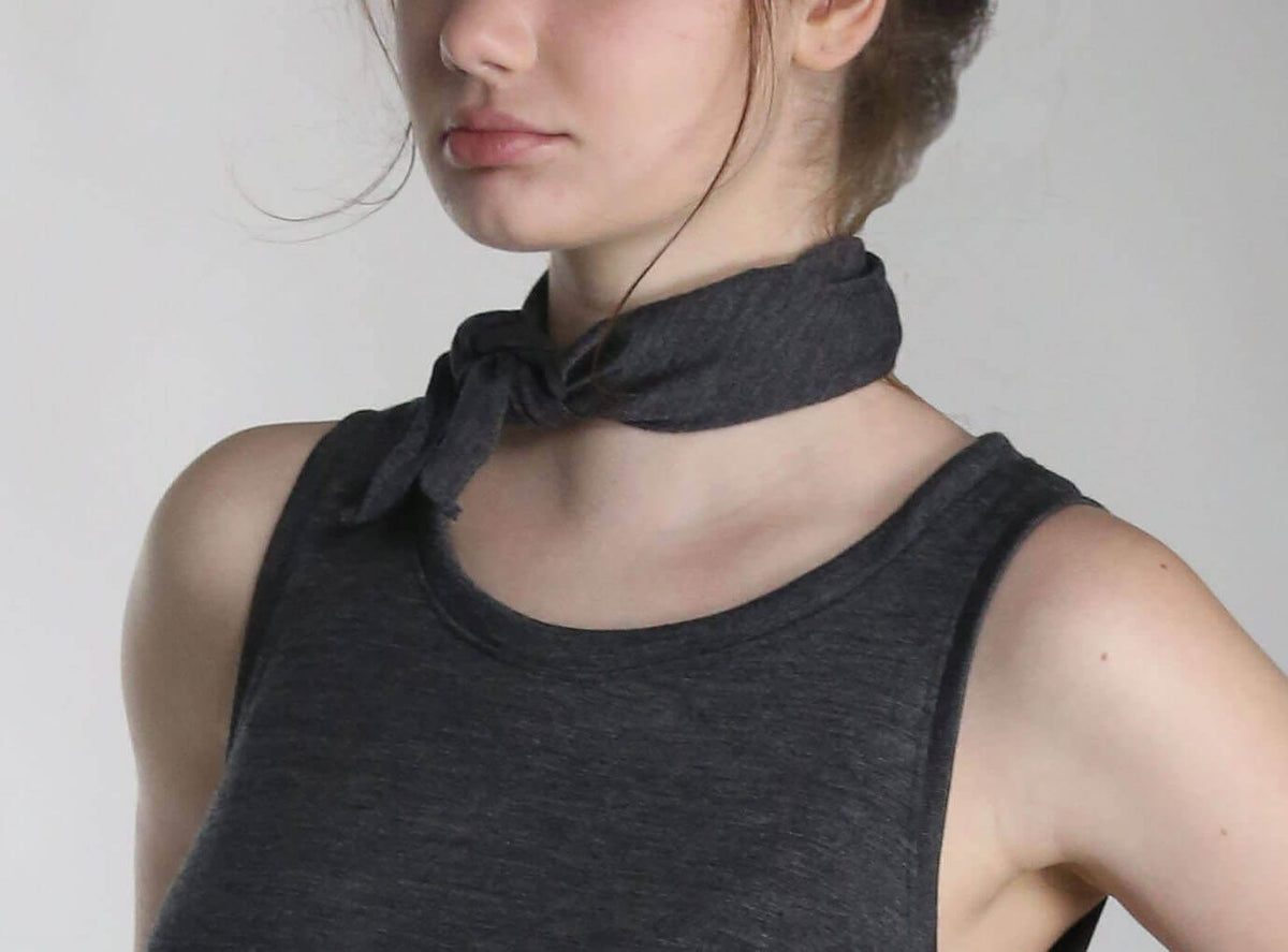 Woman wearing a merino wool bandana as a neck scarf, showcasing the versatile natural wool accessory.