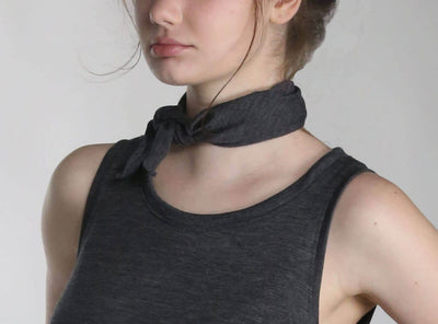 Woman wearing a merino wool bandana as a neck scarf, showcasing the versatile natural wool accessory.