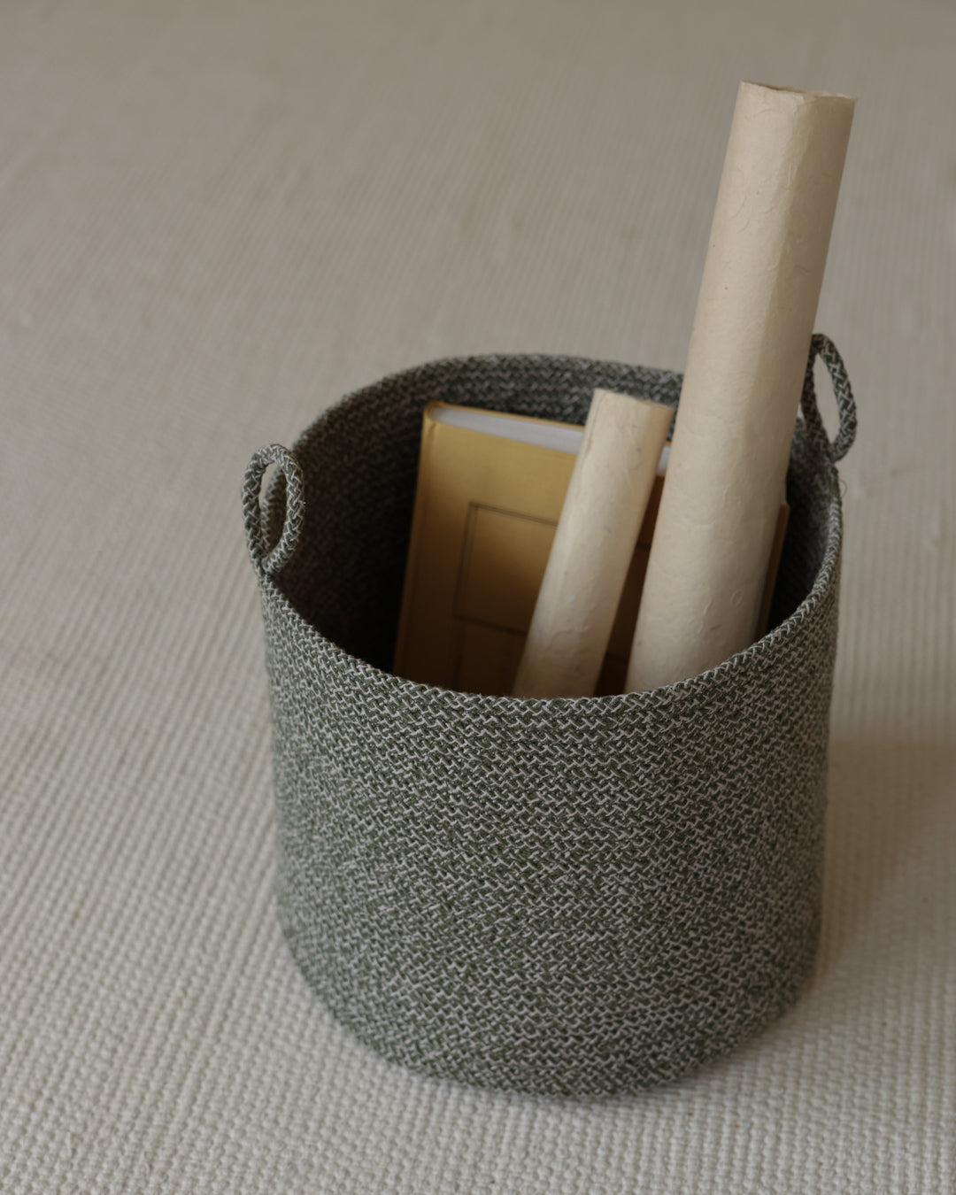 Small Green Melange Loops basket organizing rolled paper and rectangular supplies.