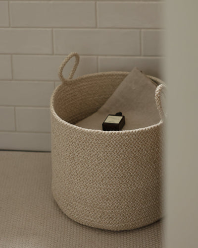 Open basket viewed from above, showing its roomy interior and stored household items.