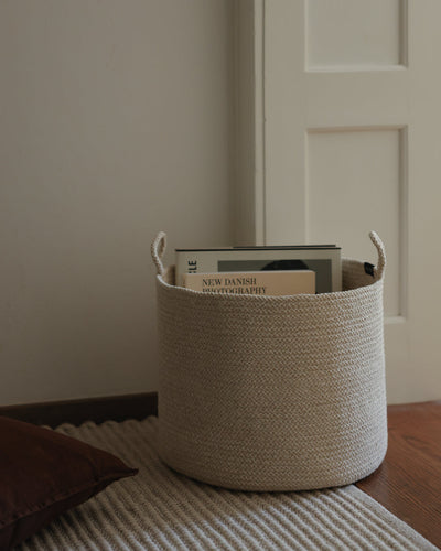 Large Beige Melange Loops basket used to store books beside a doorway.