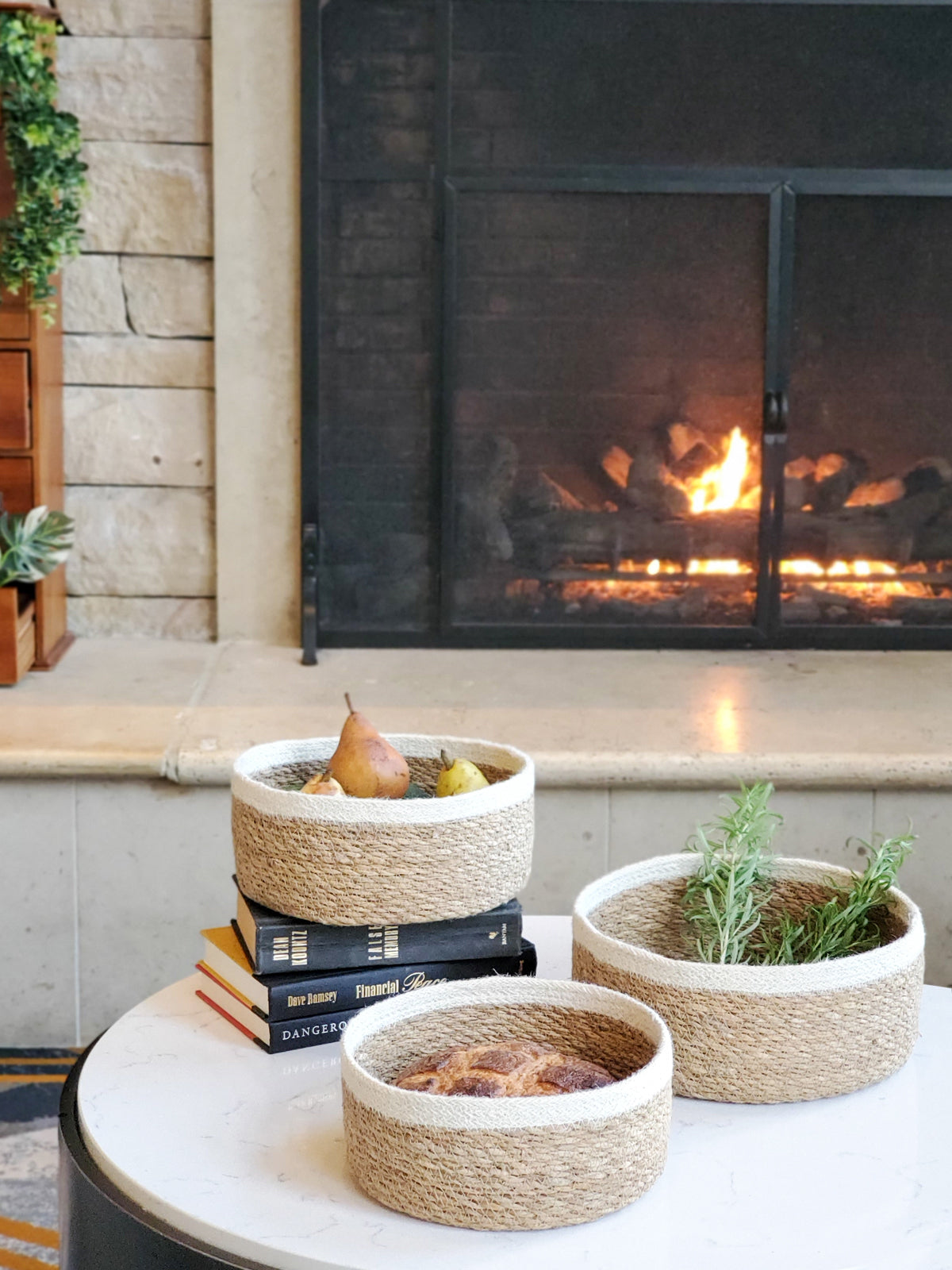 Korissa Savar Storage Bowl styled on table near fireplace with books, plant