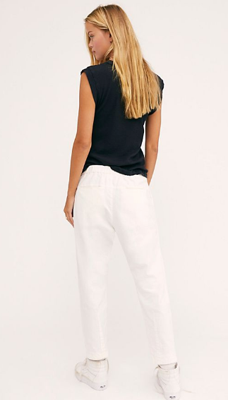 Back view of a model wearing white Souk pants with a black sleeveless top.