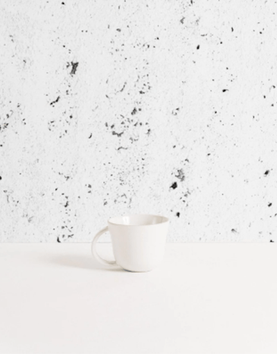 Stoneware mug in Matte White against textured concrete background