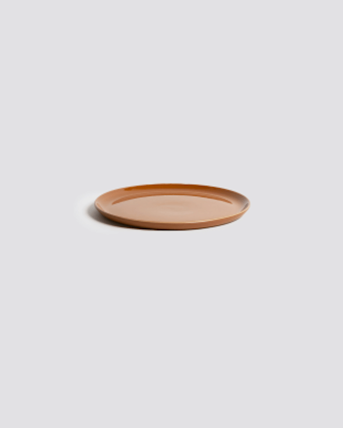 Stoneware side plate in Terracotta side profile view showing rim and glazed interior
