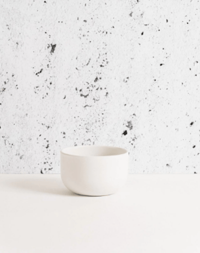 Stoneware bowl in Matte White against textured concrete background