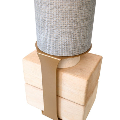 Close-up of the wooden block base secured to the gray tube with a wide tan support strap.