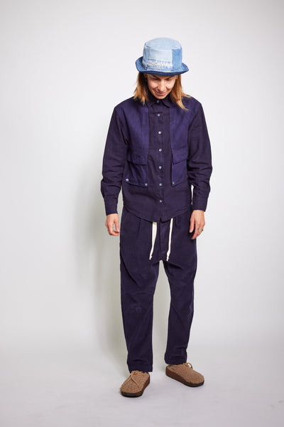 Front view of a model looking down in the navy Trek Shirt and matching pants.