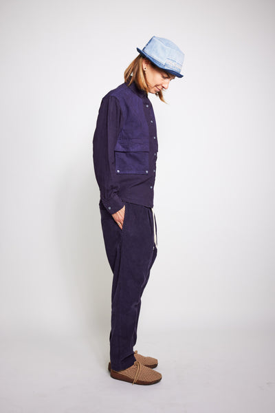 Full-length side view of the navy Trek Shirt worn with matching pants and a pale blue bucket hat.
