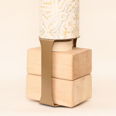 Close-up of the wooden block base secured to the tube with a wide tan strap.