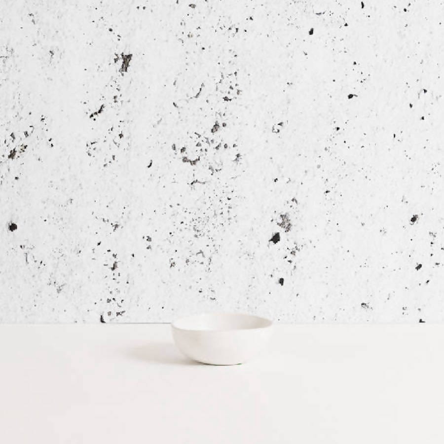 Stoneware bowl in Matte White against textured concrete background