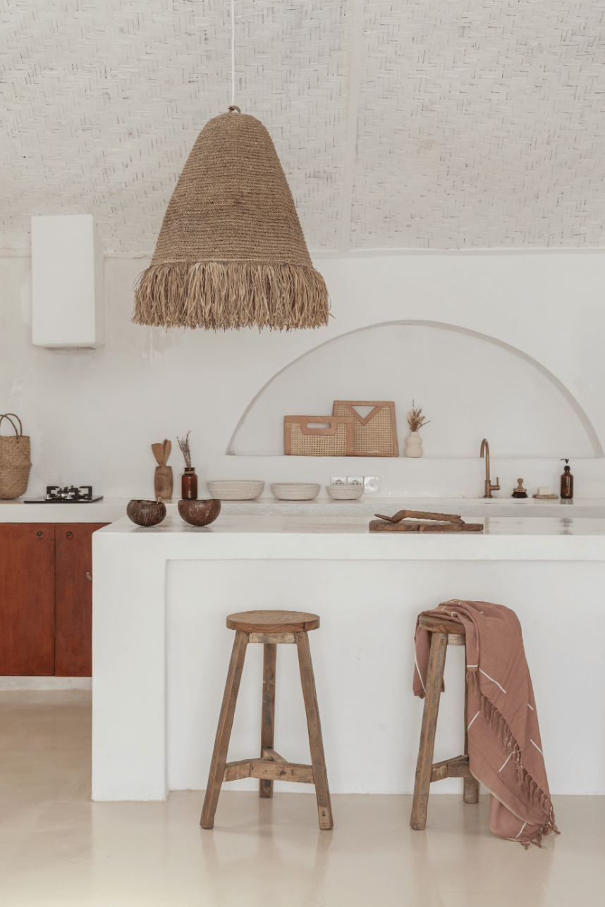 Village Thrive Lines Tapestry, taupe rayon, hanging in a kitchen above a counter and wooden stools.