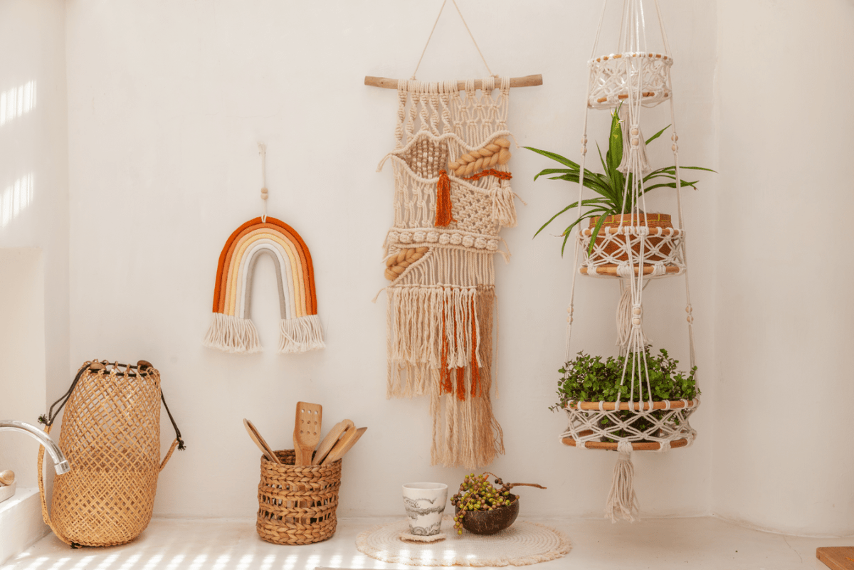 Village Thrive Mia Macrame Rainbow, pastel multicolor and terracotta cotton, two rainbows displayed among baskets and a macrame plant hanger.