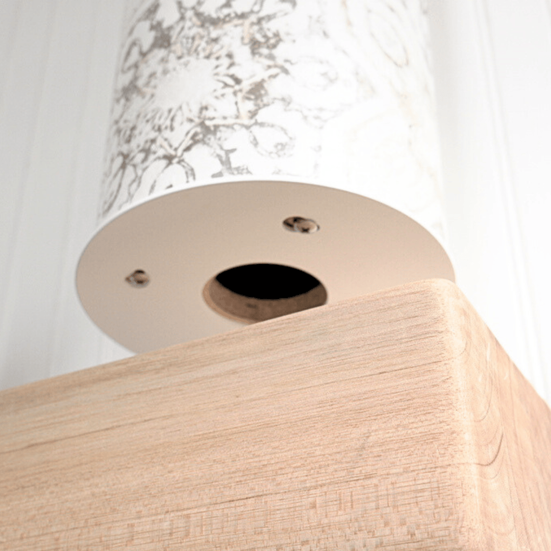 Low-angle view beneath the pale wood base, showing a circular opening and metal fasteners.