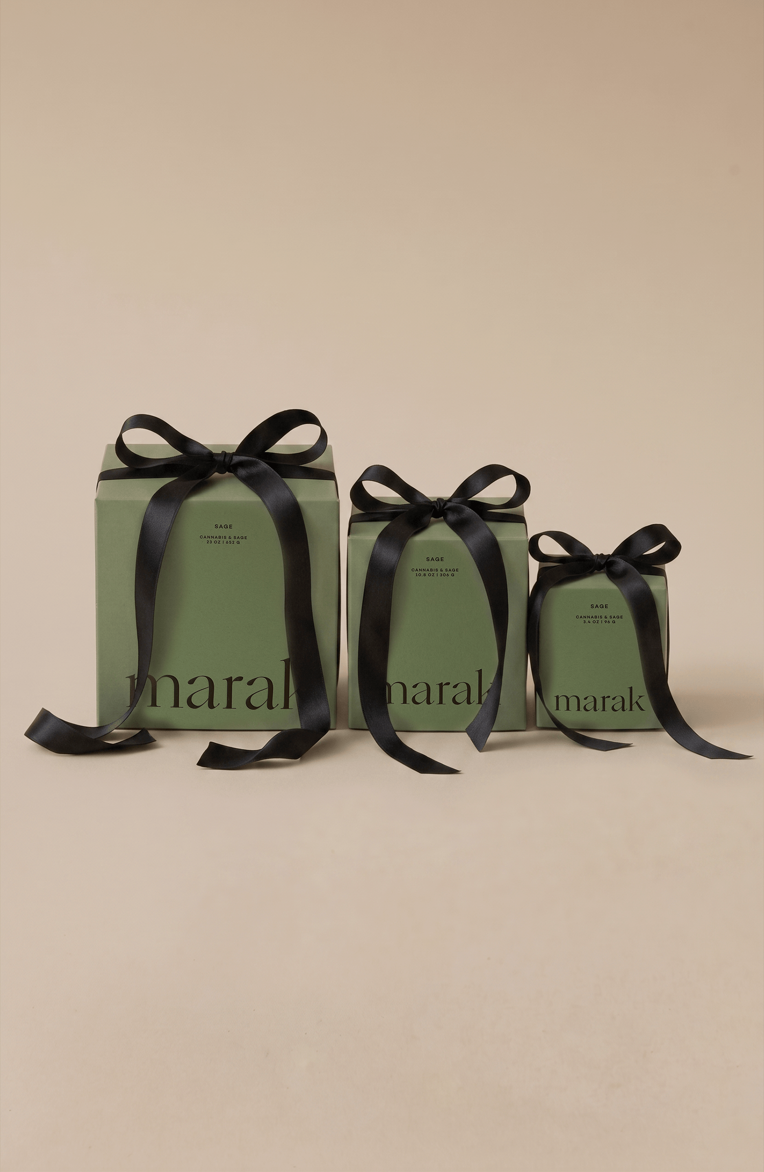 Three green boxes with black ribbons on a beige background