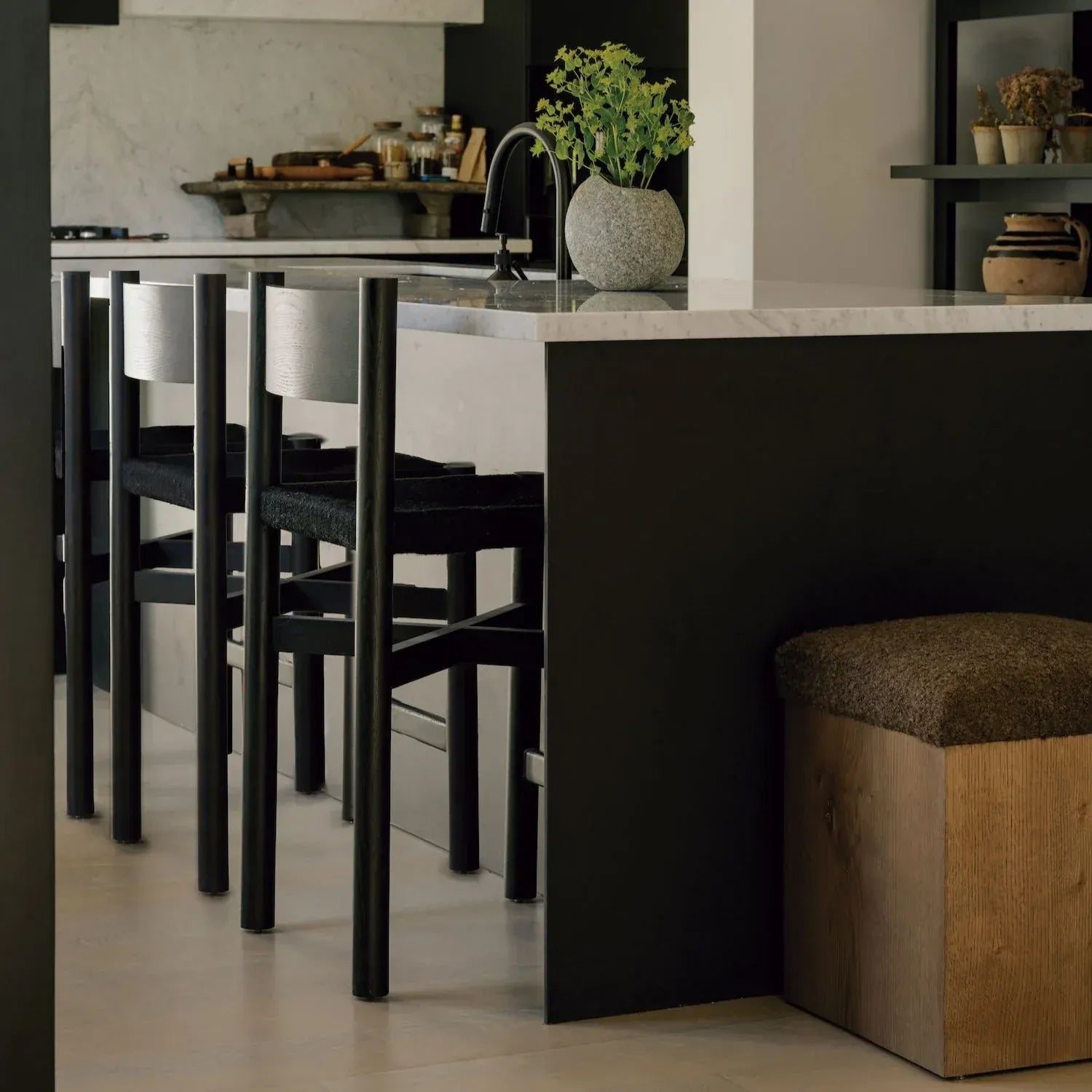 Modern kitchen with wooden table and chairs, large window, and potted plant in Riverstone Vase showcasing the Nonna Counter Stool by House of Leon