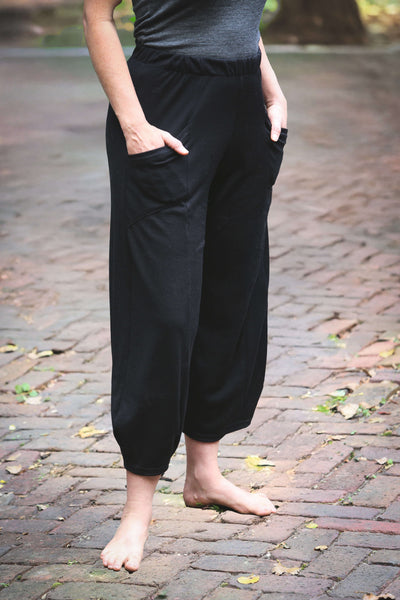Black merino wool lounge pants featuring a fluid full-leg design, breathable warmth, and a comfortable elastic waistband.