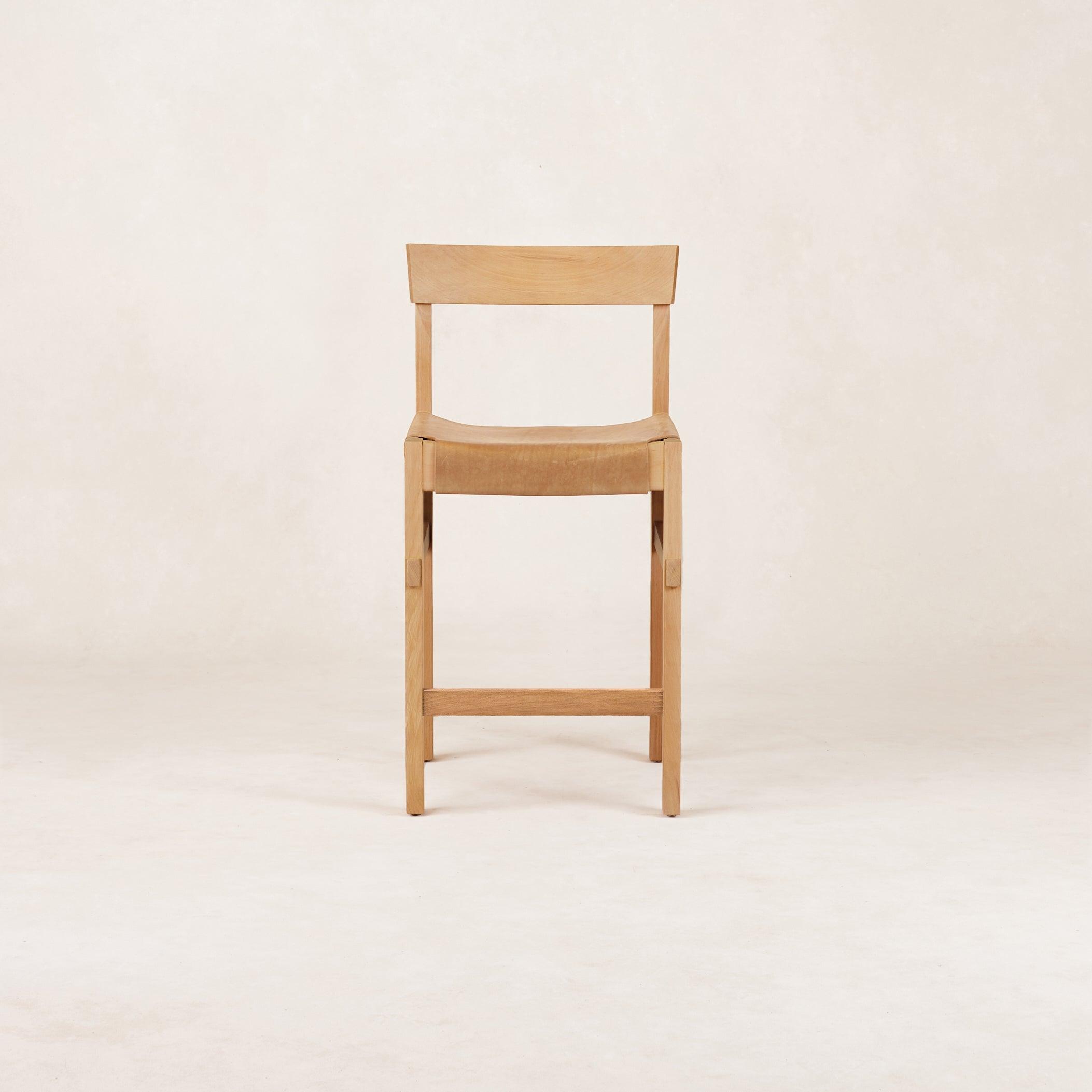 A beige Shinto Counter Stool with a leather seat and wooden frame, inspired by the Torii Gate from Japanese Shinto shrines.