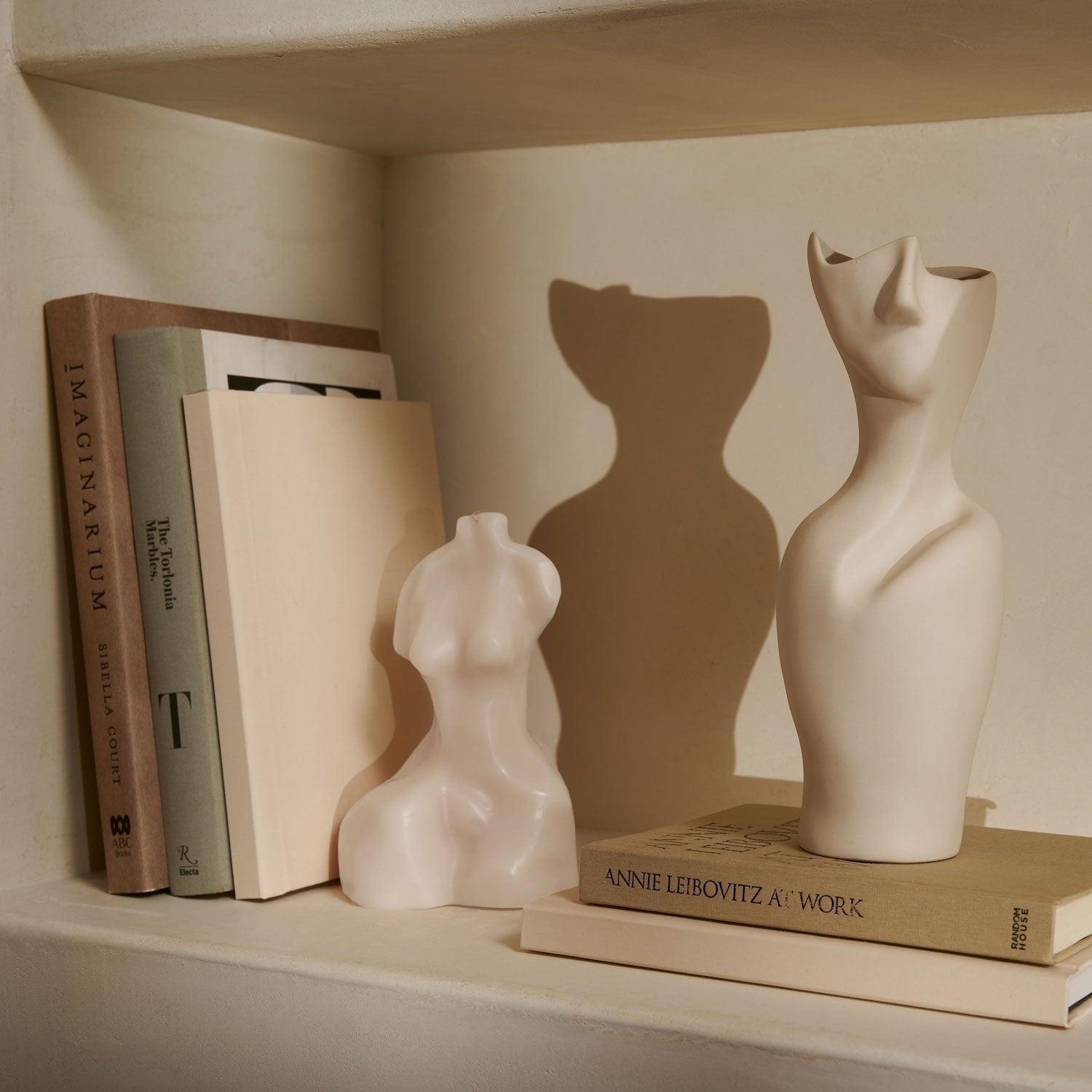Delphina Candle in shelf with books