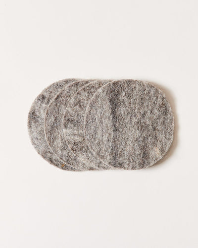 Stack of round heather-gray felt coasters, slightly fanned to show their thick, soft edges and natural fiber texture.