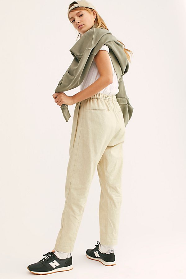Back three-quarter view of natural cream Canvas Souk pants worn with a white shirt, olive sweatshirt, and sneakers.