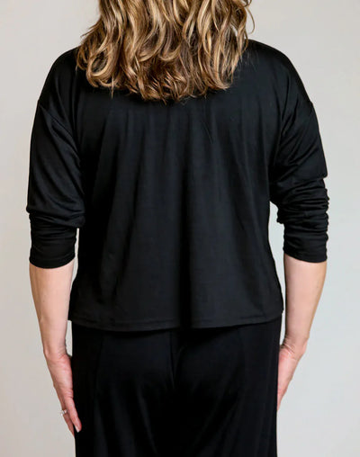 Back detail of a black merino wool lounge top featuring a relaxed fit and breathable natural wool construction.