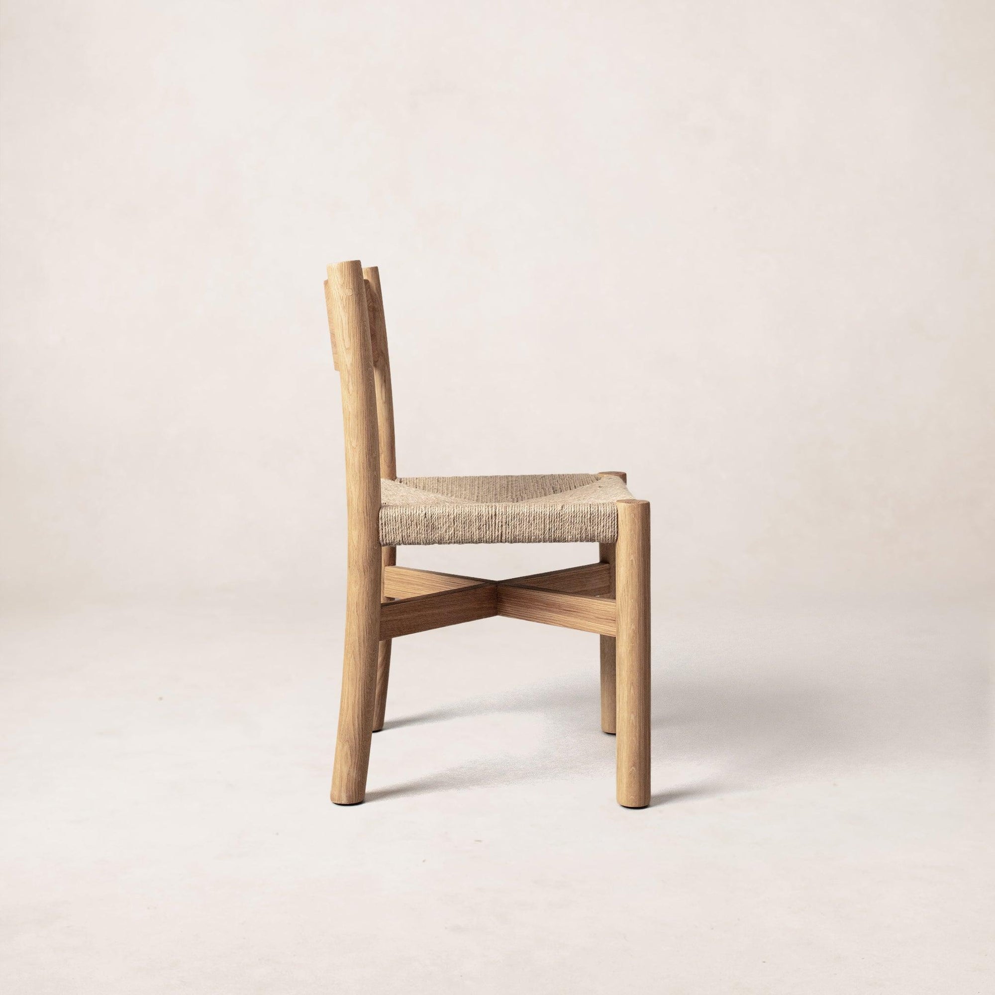 Side view of Nonna dining chair showing curved backrest and jute seat
