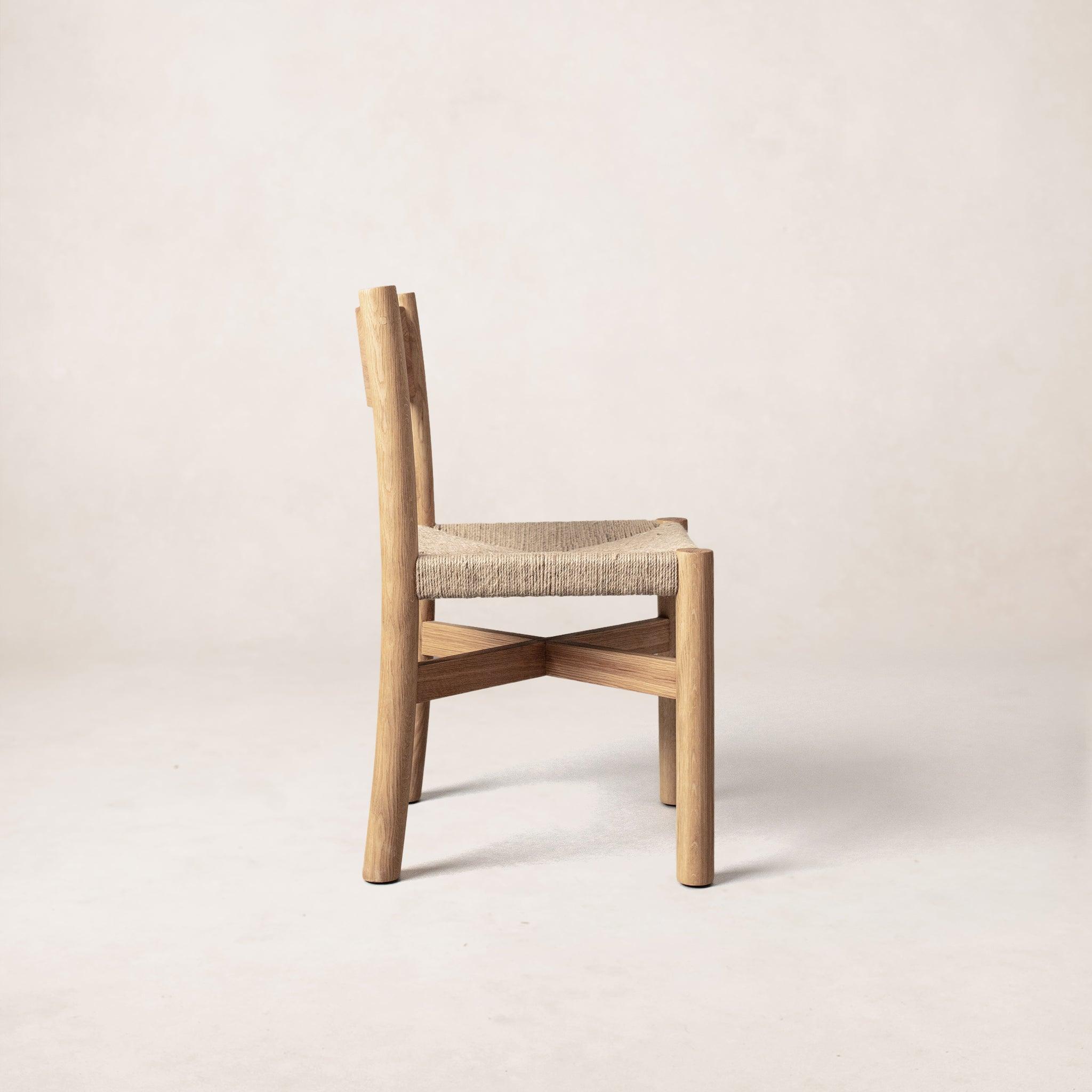 Side view of Nonna dining chair showing curved backrest and jute seat