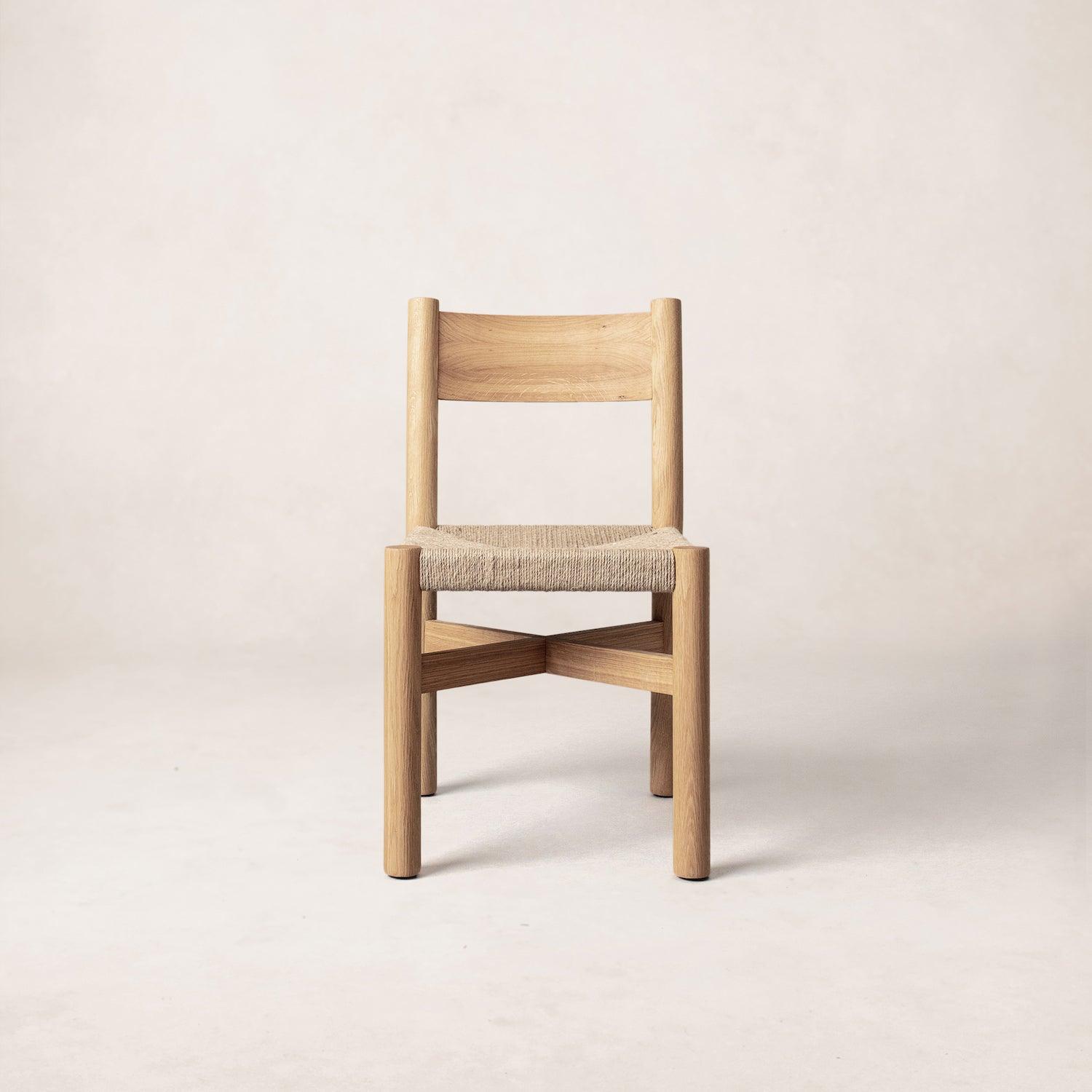 A single Nonna dining chair with a white oak frame and a soft woven seat, displayed against a neutral background.
