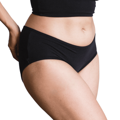 Model wearing Organic Cotton Mid-Rise Brief in Black, side view