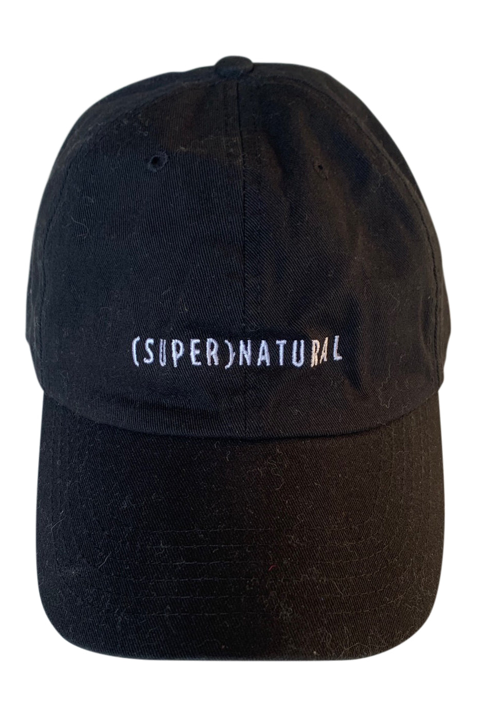 Front product view of a black SUPERNATURAL cap with white embroidered lettering.