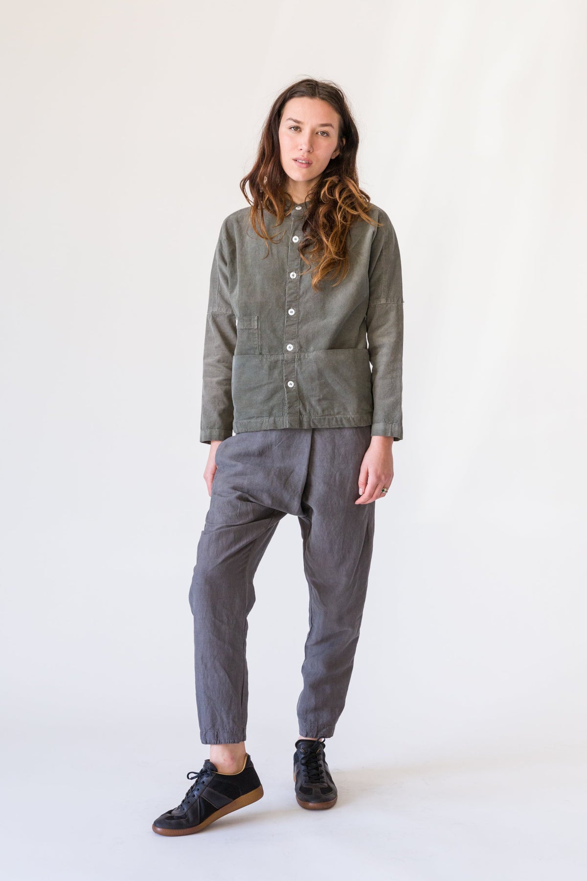 Full-length view of a model wearing a charcoal Raj coat with gray cropped pants and black shoes.