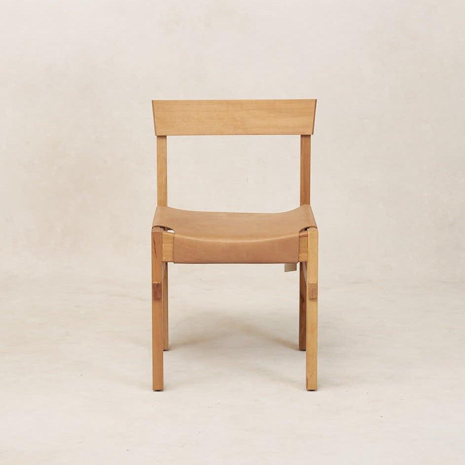 A natural colored Shinto dining chair with a wooden frame and leather seating, displayed against a neutral background.