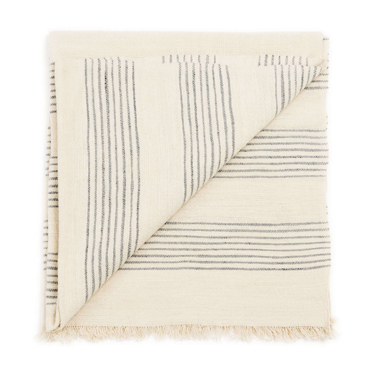 Variously Silica Chalk handwoven throw folded to show its off-white weave, fine gray stripe pattern and short fringed edge