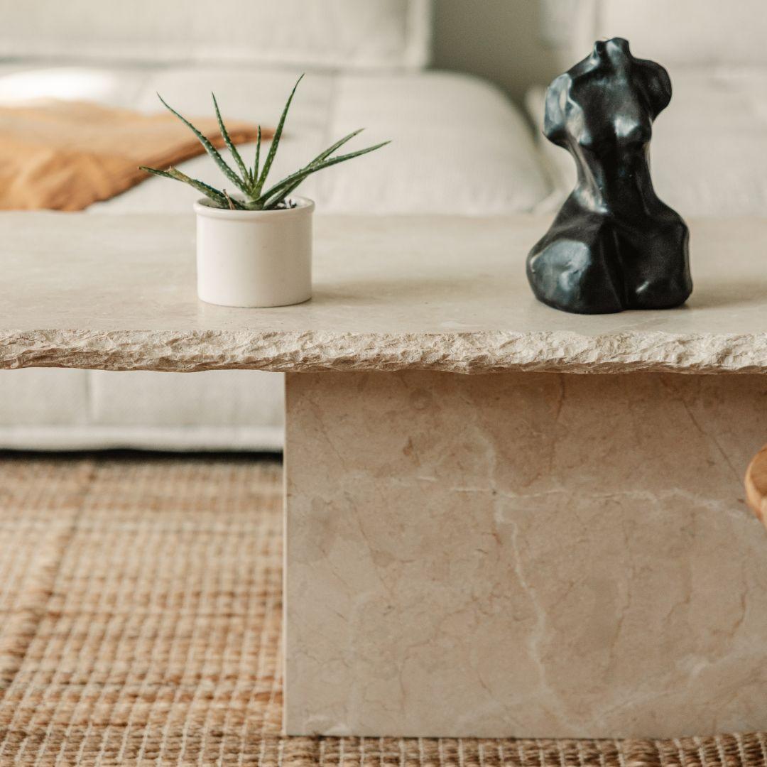 Close-up of Sofita marble coffee table showing chipped stone edge and subtle veining
