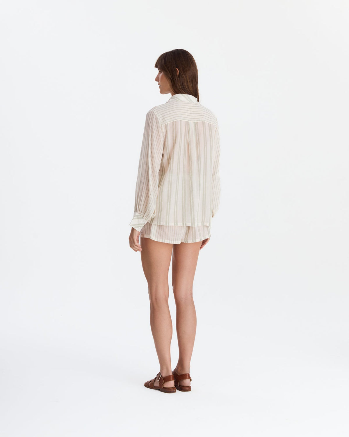 Back view showing the shirt’s horizontal striped shoulder panel, vertically striped back, matching shorts, and brown sandals.