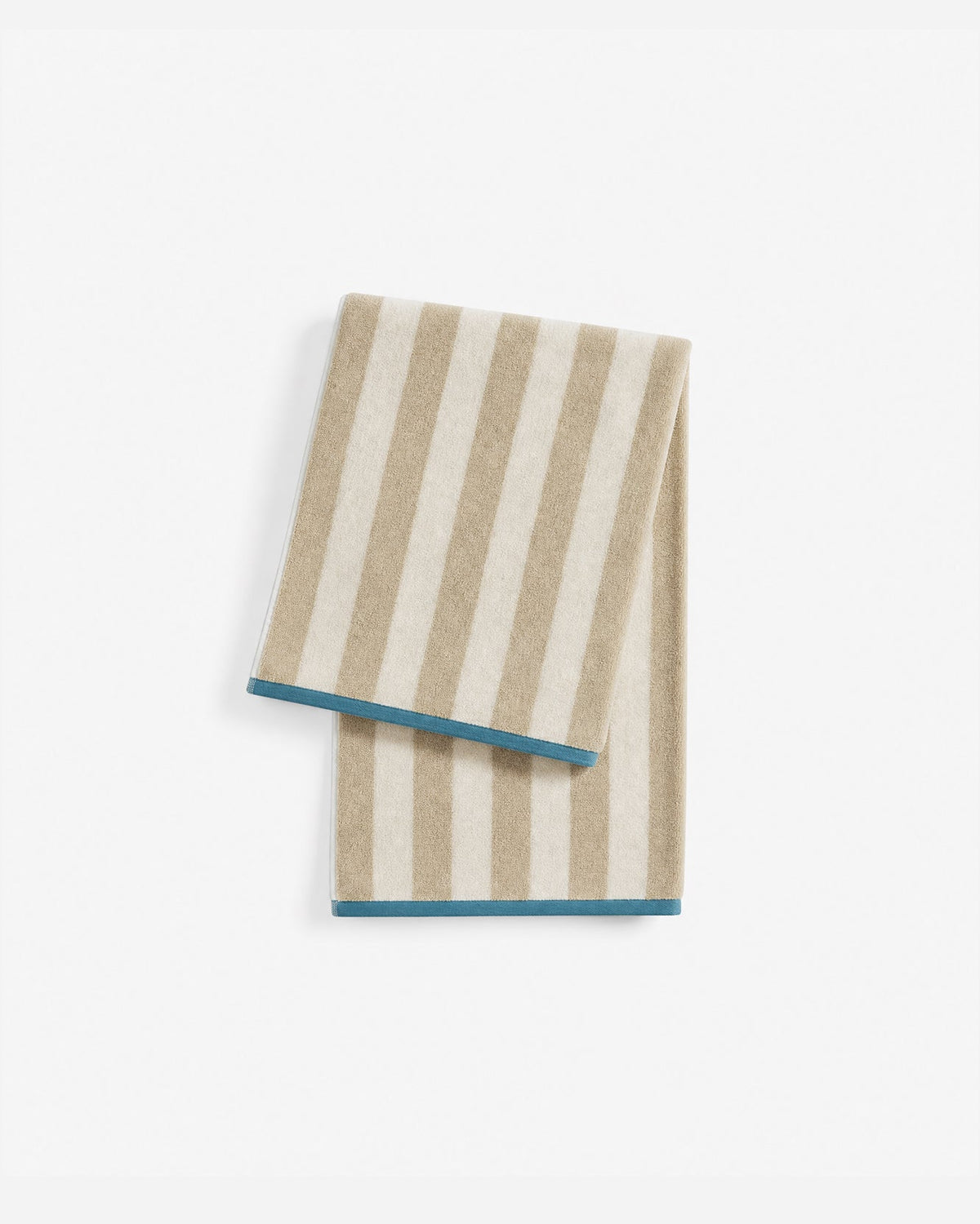 Folded beige and cream Serena Beach Blanket with contrasting vertical and horizontal stripes, with one corner turned back to reveal cream fringe.